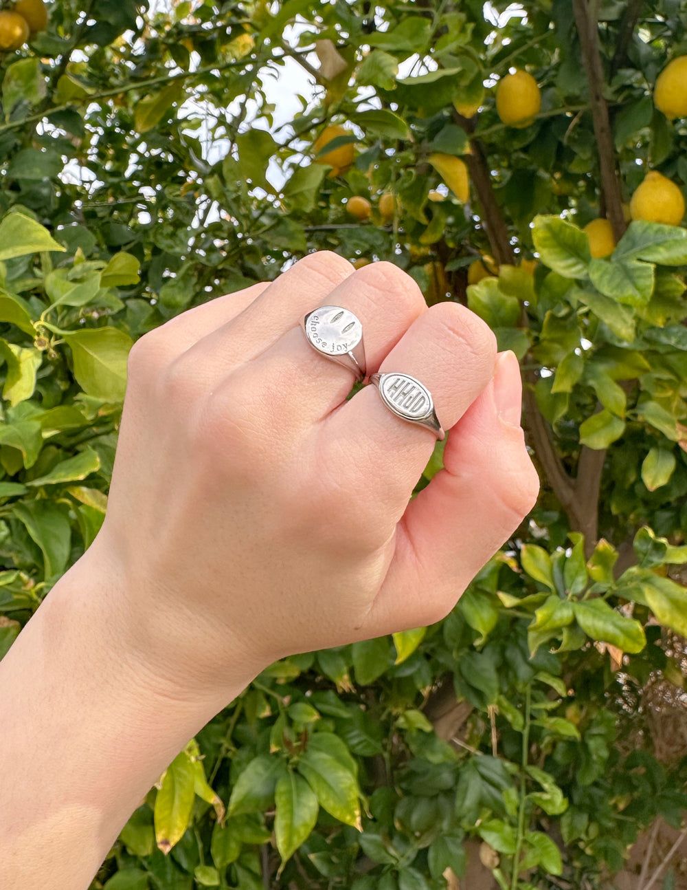Hand wearing a silver oval WWJD signet ring