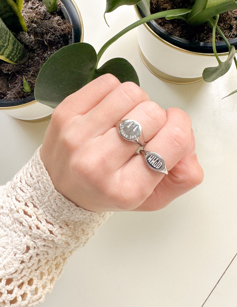 Hand wearing silver oval WWJD signet rings