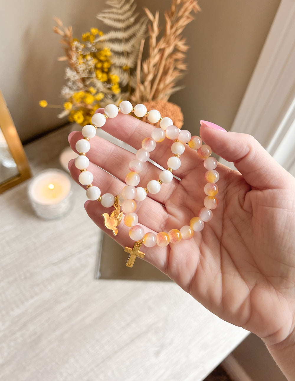 Beaded cross charm bracelet with pink and white beads and gold cross pendant