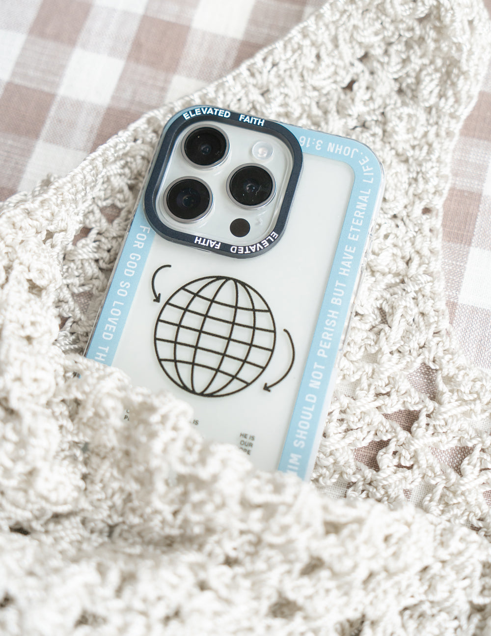 Light blue phone case with black globe graphic and faith quote along the edge
