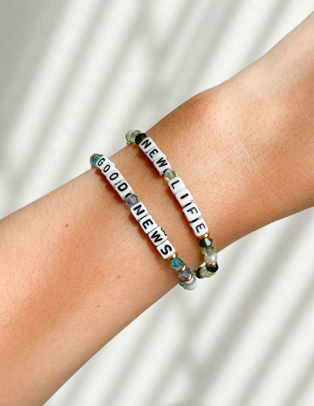 White and green beaded 'NEW LIFE' bracelet with dark letter beads and gold details