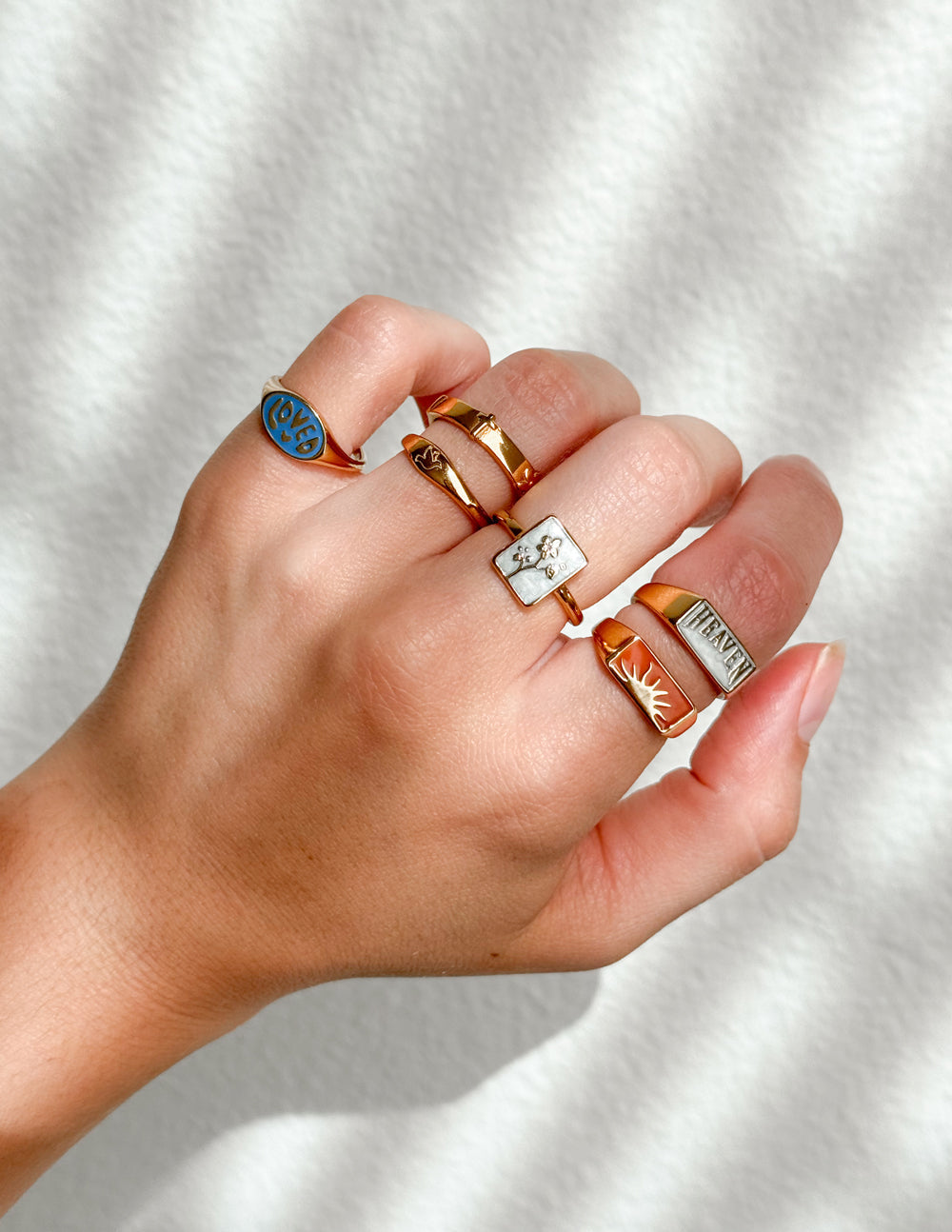 Gold signet ring with blue enamel oval face marked LOVED close-up