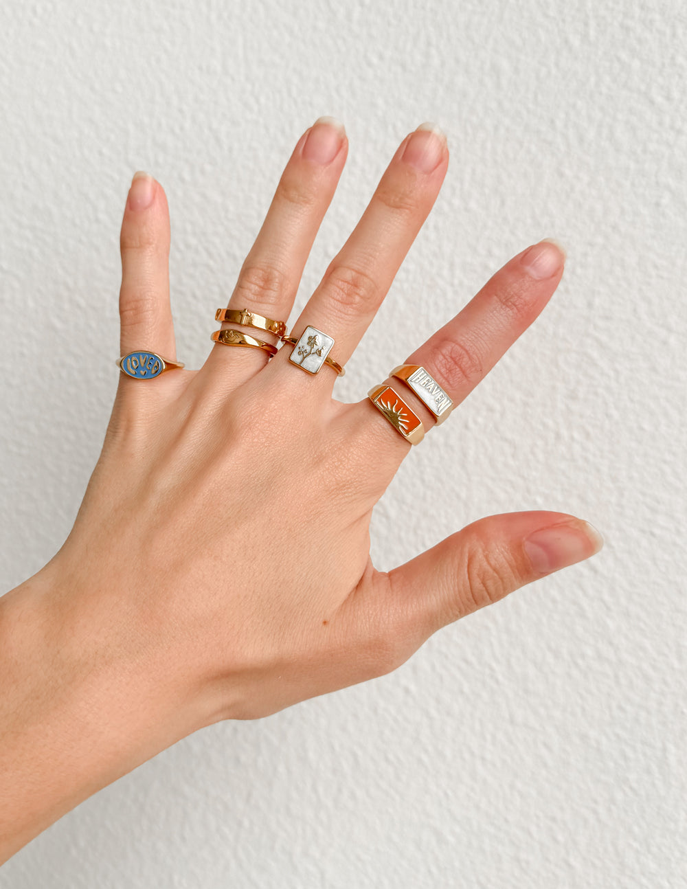 Orange enamel rectangular signet ring with gold-tone border on hand