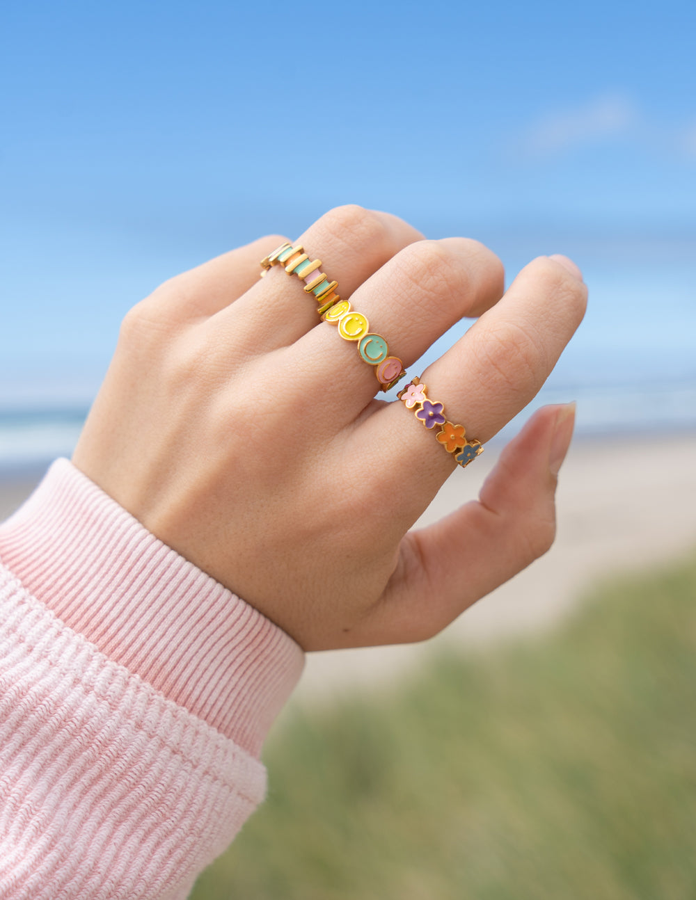 Gold-tone enamel flower band ring with teal, yellow, and purple floral charms