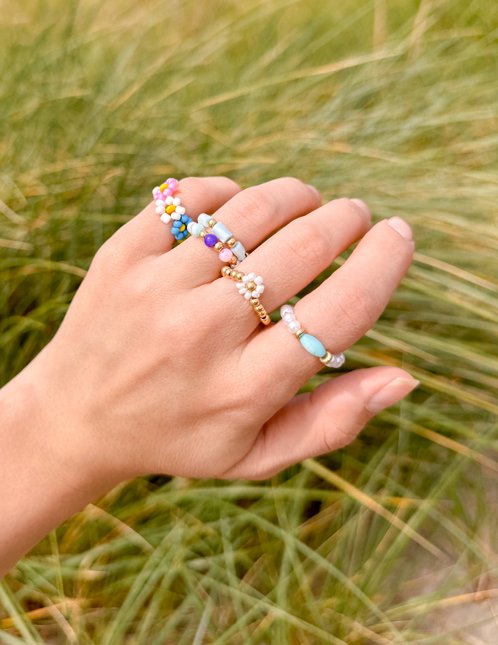 Pastel beaded ring set on hand with turquoise, pink and white bead details