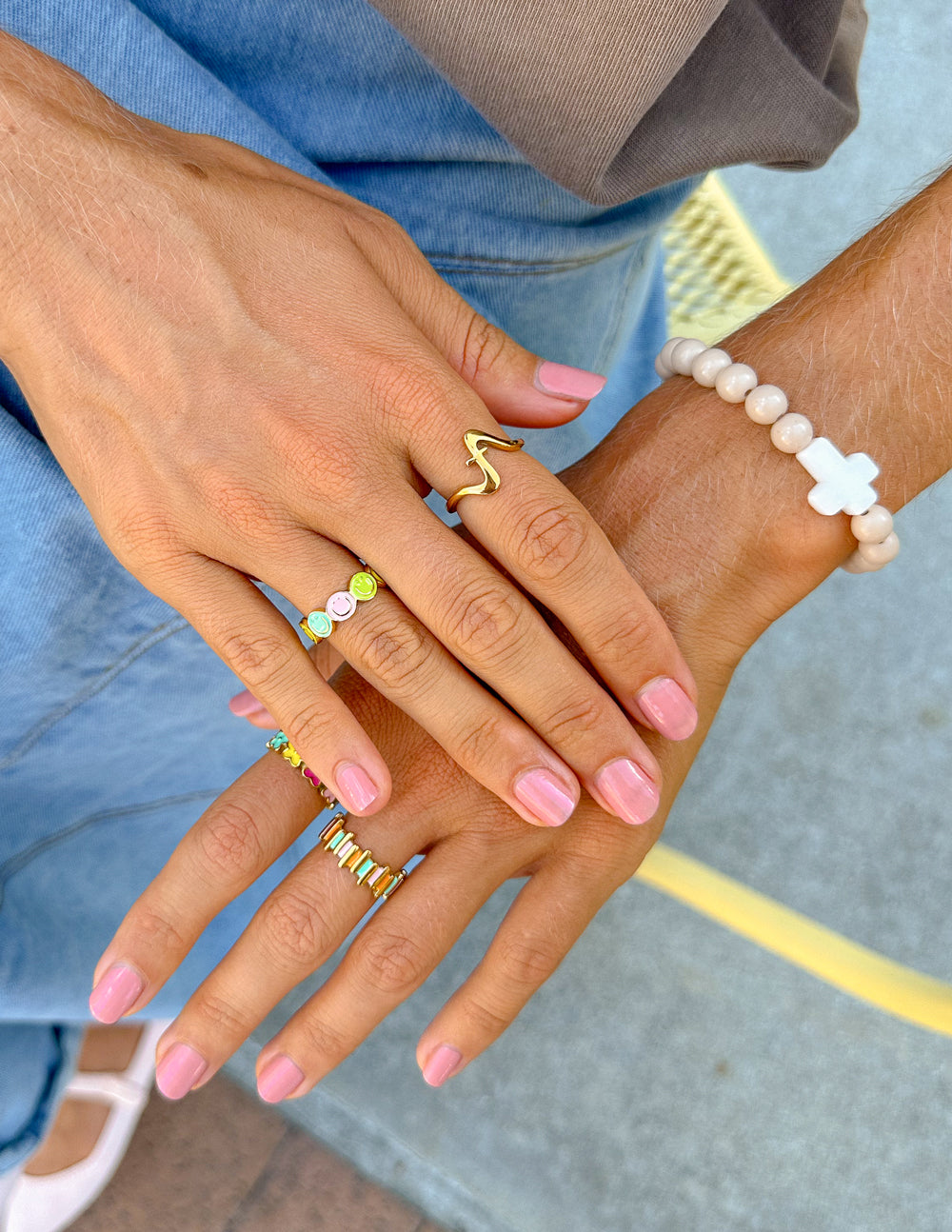 Gold wavy cross ring on hand, open band with cross motif