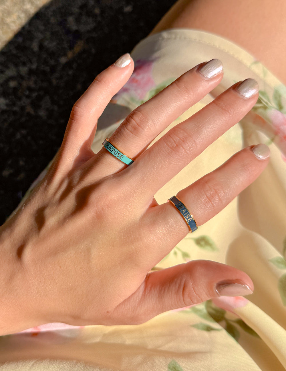 Navy enamel praise band ring on finger with gold rim and “PRAISE” text
