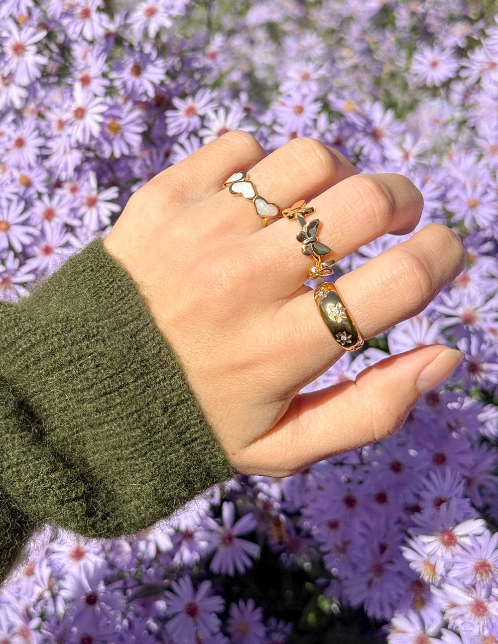 Gold-tone floral dome ring with dark stone flower settings and wide curved band
