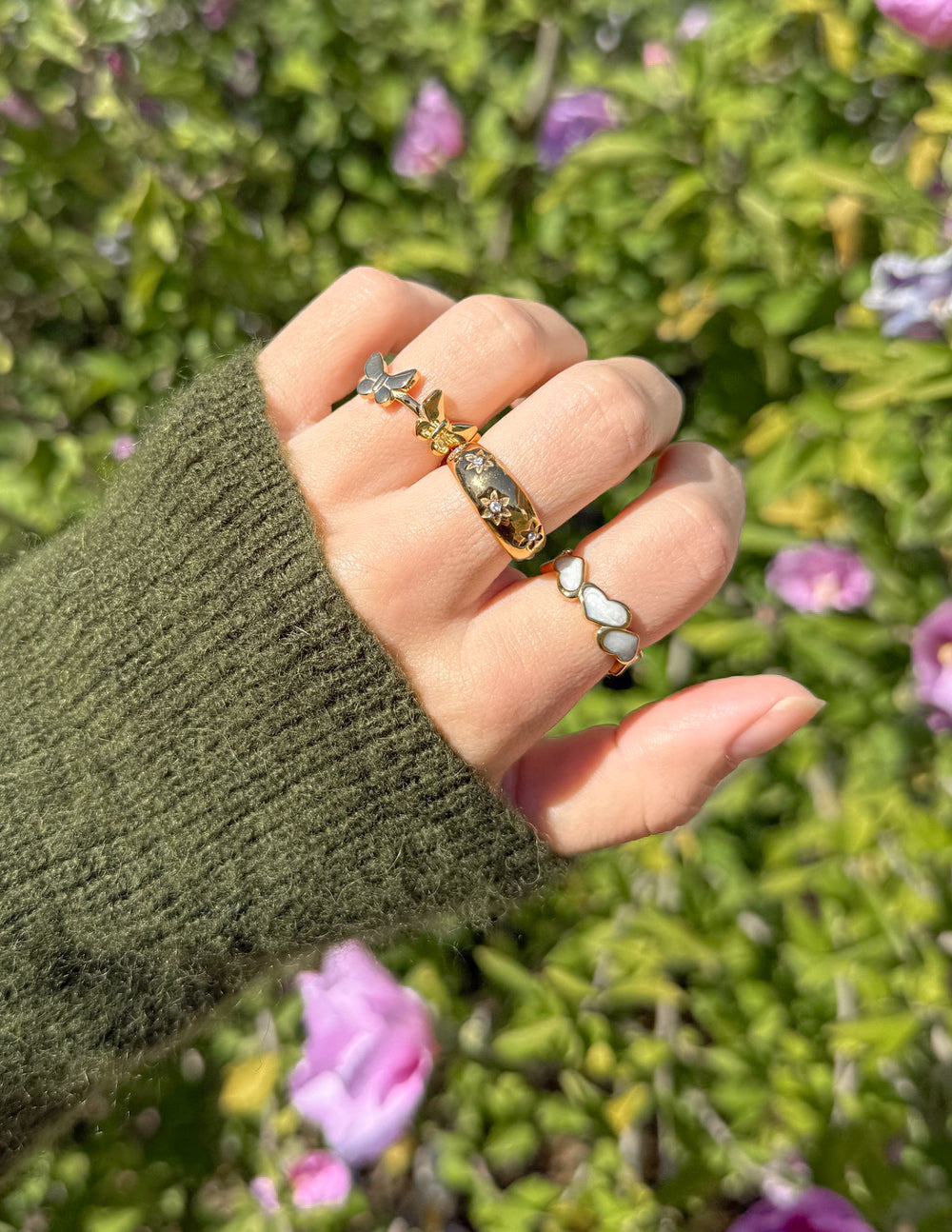 Gold butterfly motif ring with green stones and double butterfly center