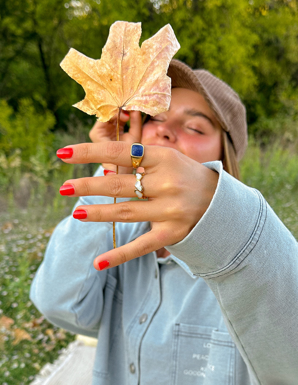 Gold ring with dark blue square stone on finger