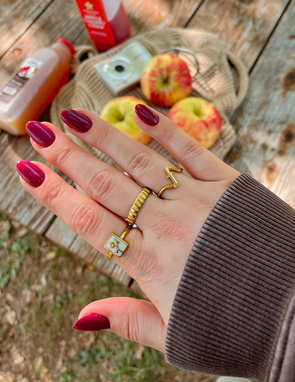 Gold wavy cross ring on hand, open curved band with cross detail