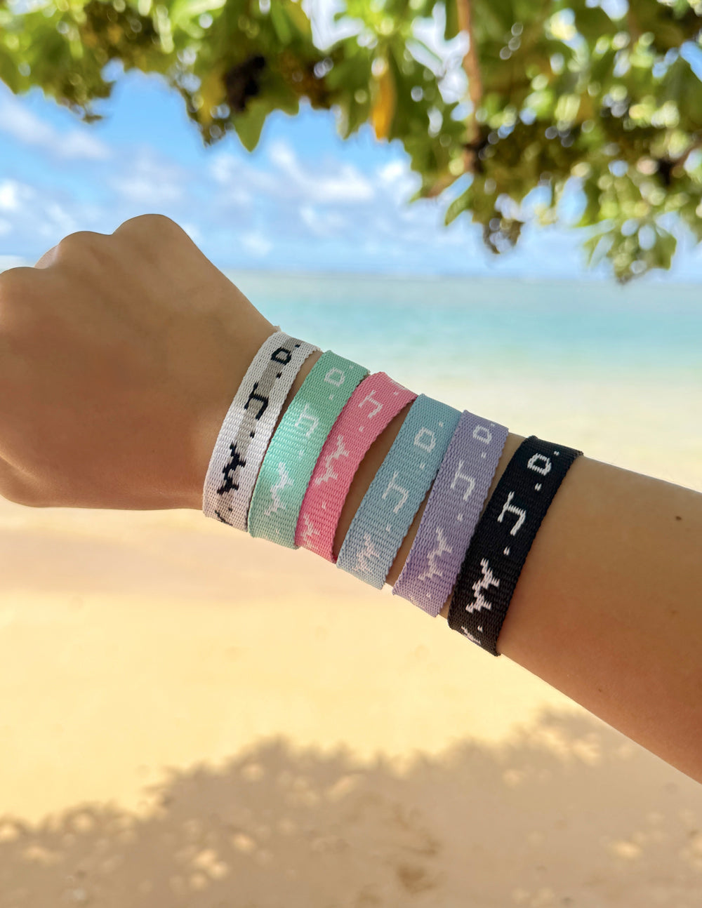 Multi-color woven WWJD-style friendship bracelet set on a wrist