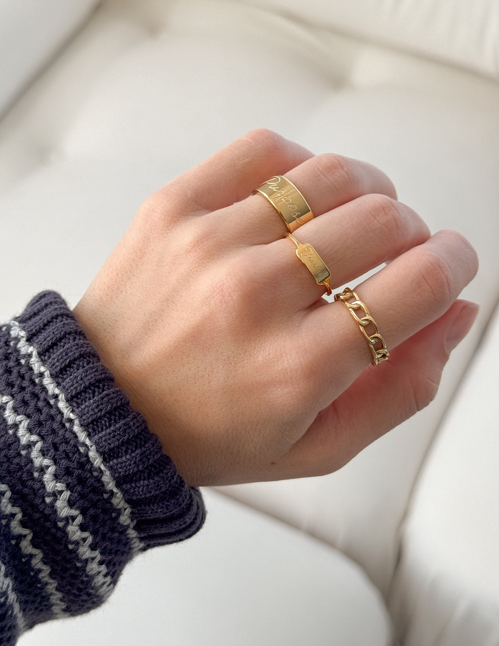 Gold Fearless signet ring with slim band stacked on finger