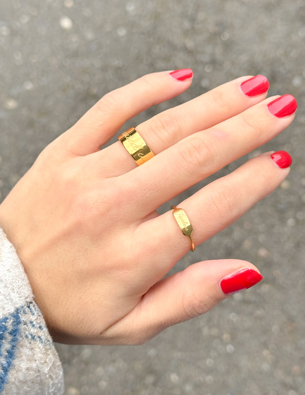 Gold Fearless signet ring and slim band on hand