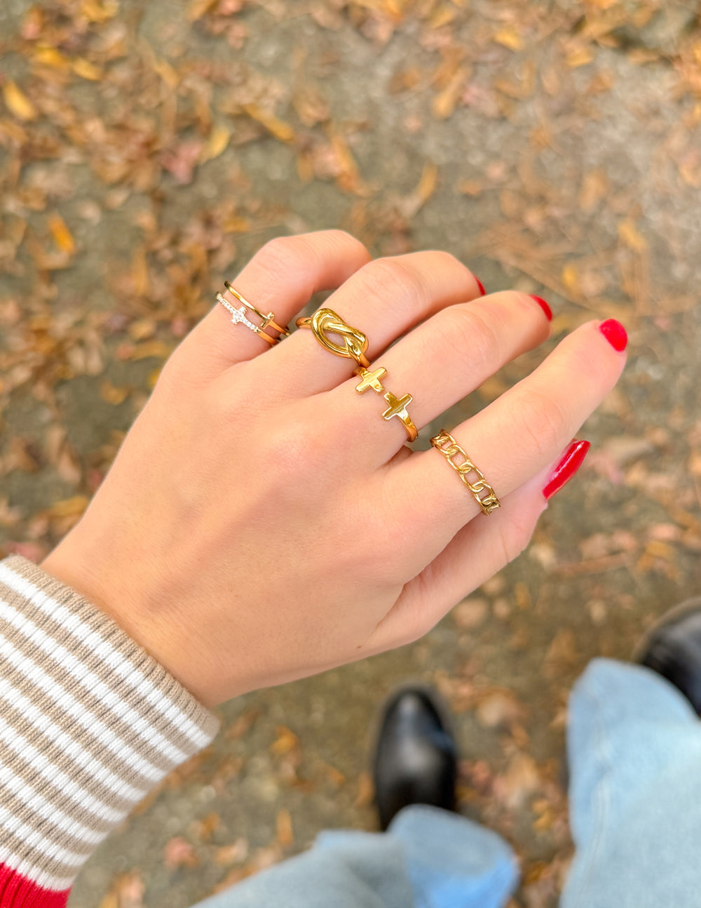 Gold knot ring with a cross-accent band, smooth polished surface