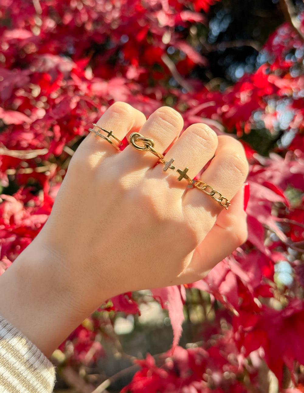 Gold-tone cross ring with two cross cutouts and hoop detail, worn on finger