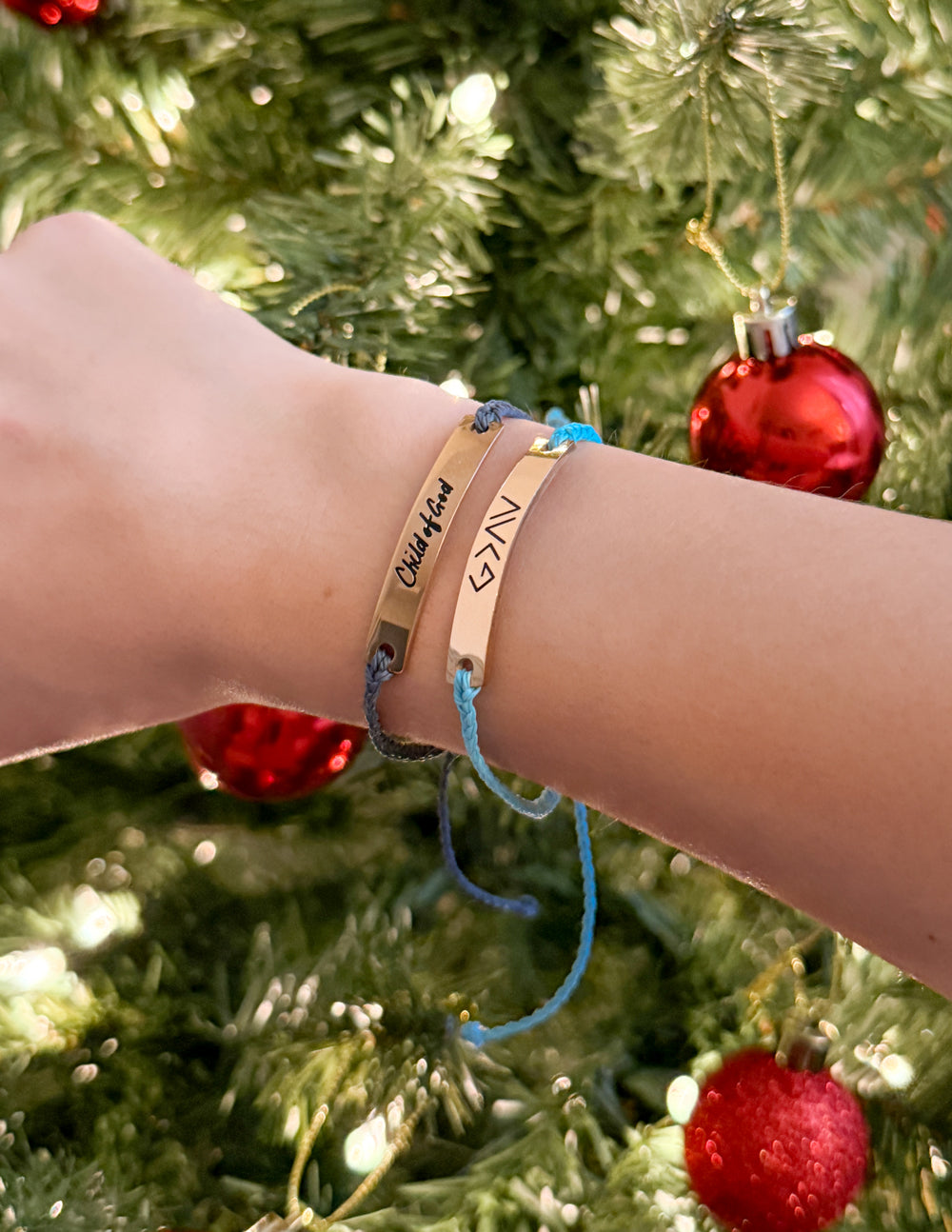 Bracelets on wrist with tan leather band and blue and black cord