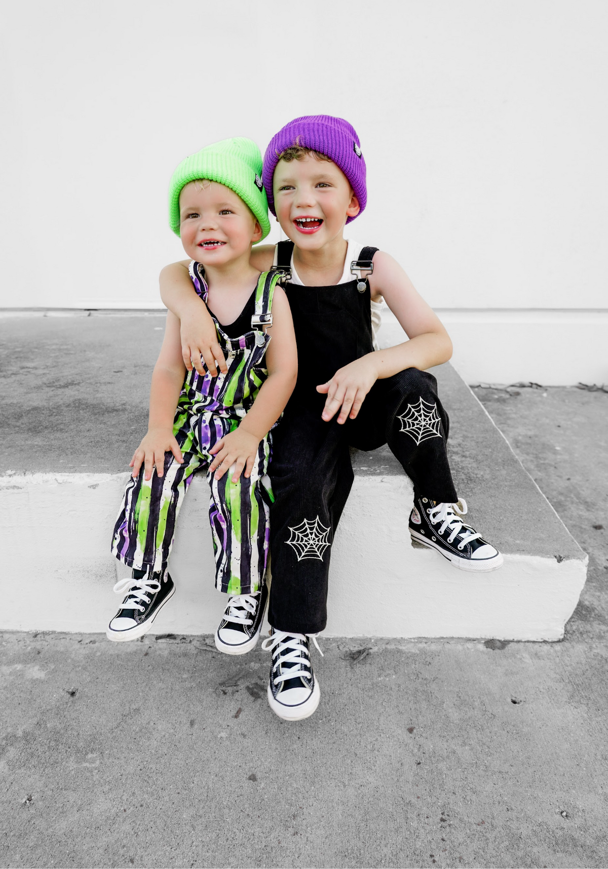 Kids Halloween outfits: striped overalls with neon green and purple accents and sneakers