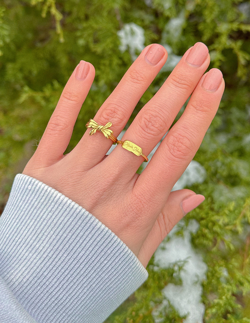 Gold ring set with engraved band and bow-style charm