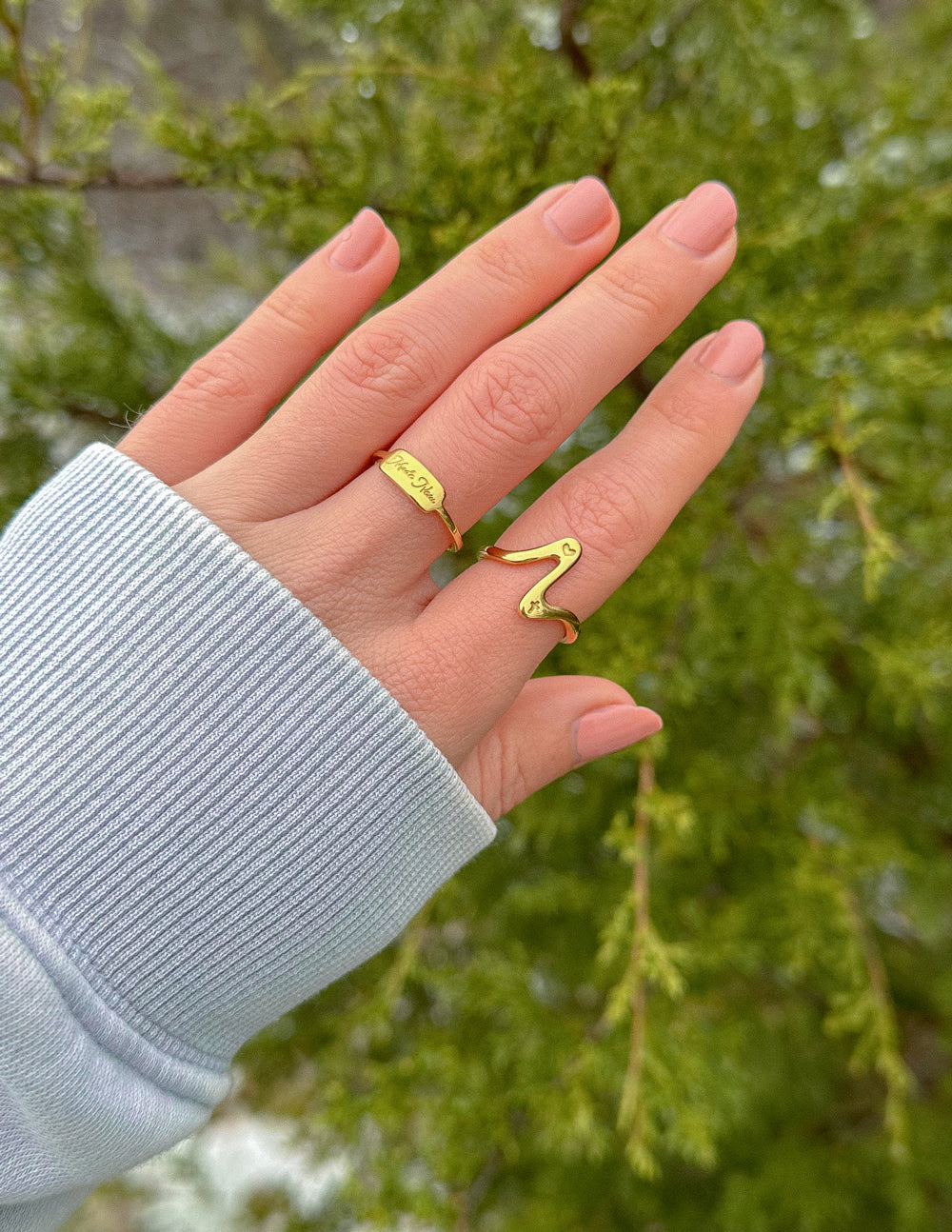Gold wavy heart ring on finger with two-band stack look, open heart motif
