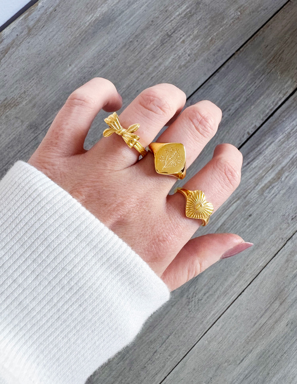 Gold heart signet ring with radiant sunburst rays and cross