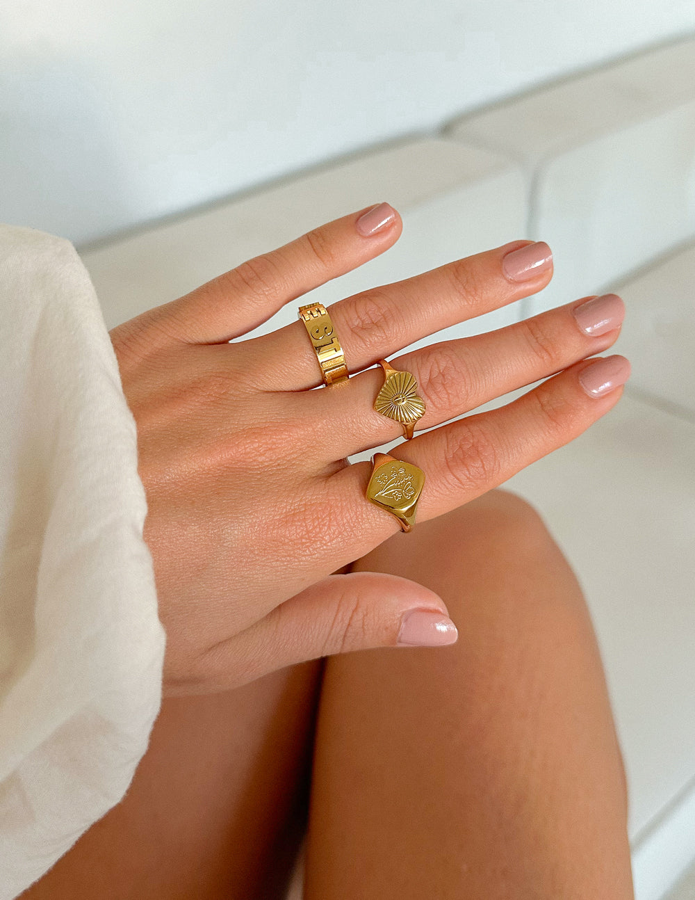 Gold heart ring with radiant rays and cross detail on finger