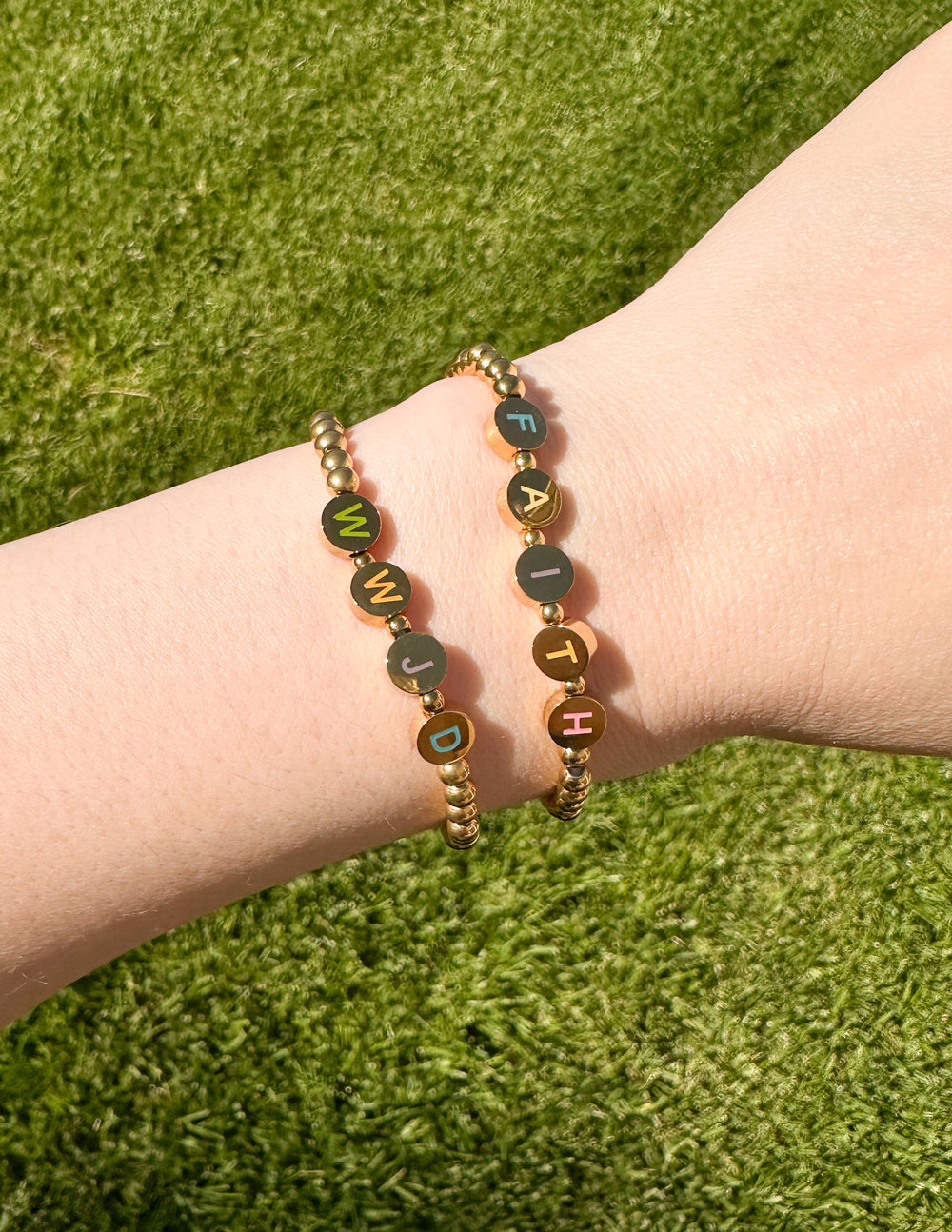 Gold beaded letter bracelet with dark enamel letter charms on round beads