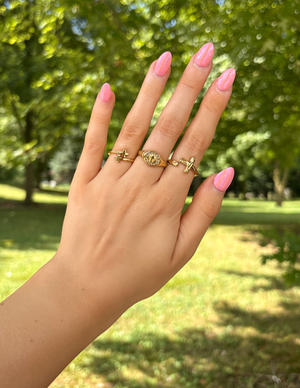 Gold cross wrap ring with cross charm on slim band, worn on finger