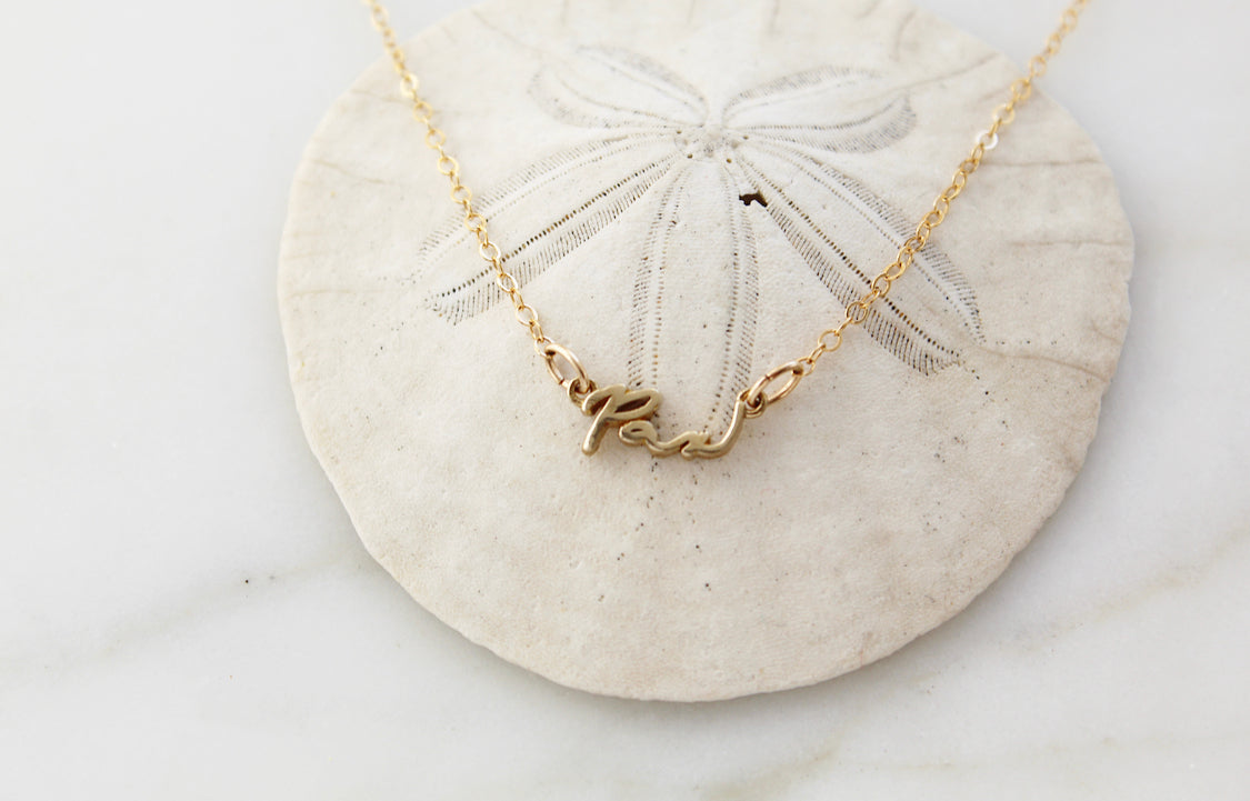 Gold Pax necklace with cursive script pendant on chain