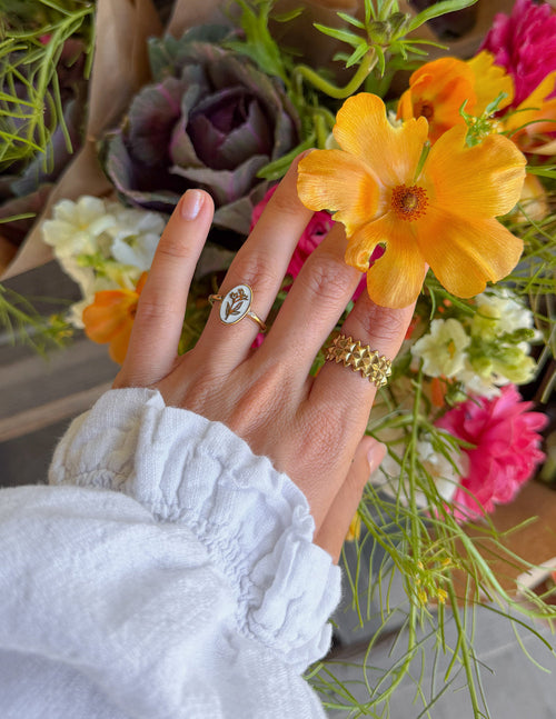 Gold enamel oval floral ring with a tiny stone detail near the setting