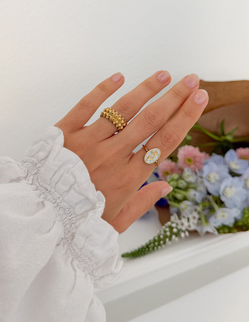 Gold enamel oval floral ring with raised setting on the finger