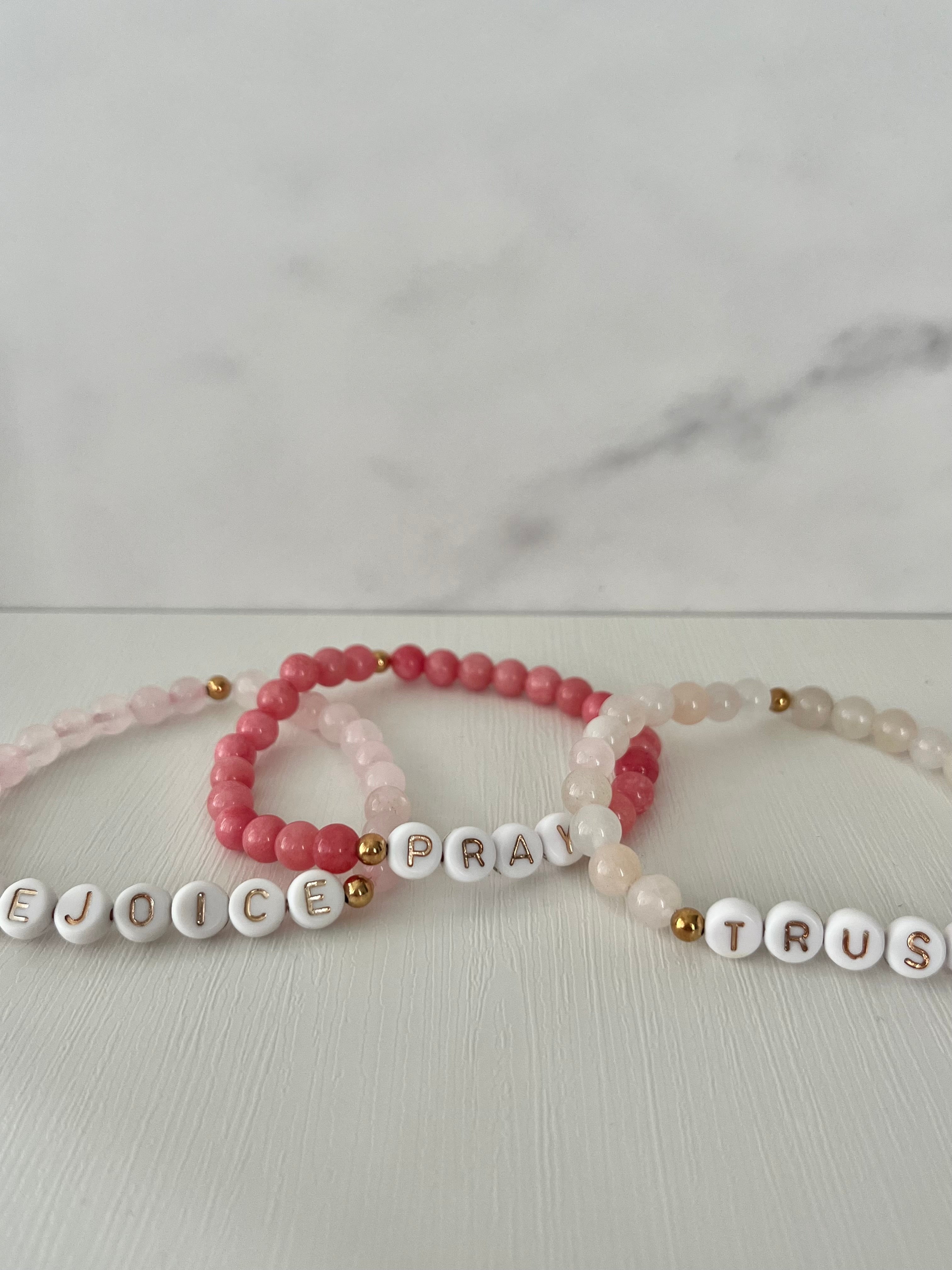 Beaded bracelet set with red Pray beads and cream Trust beads, gold accents