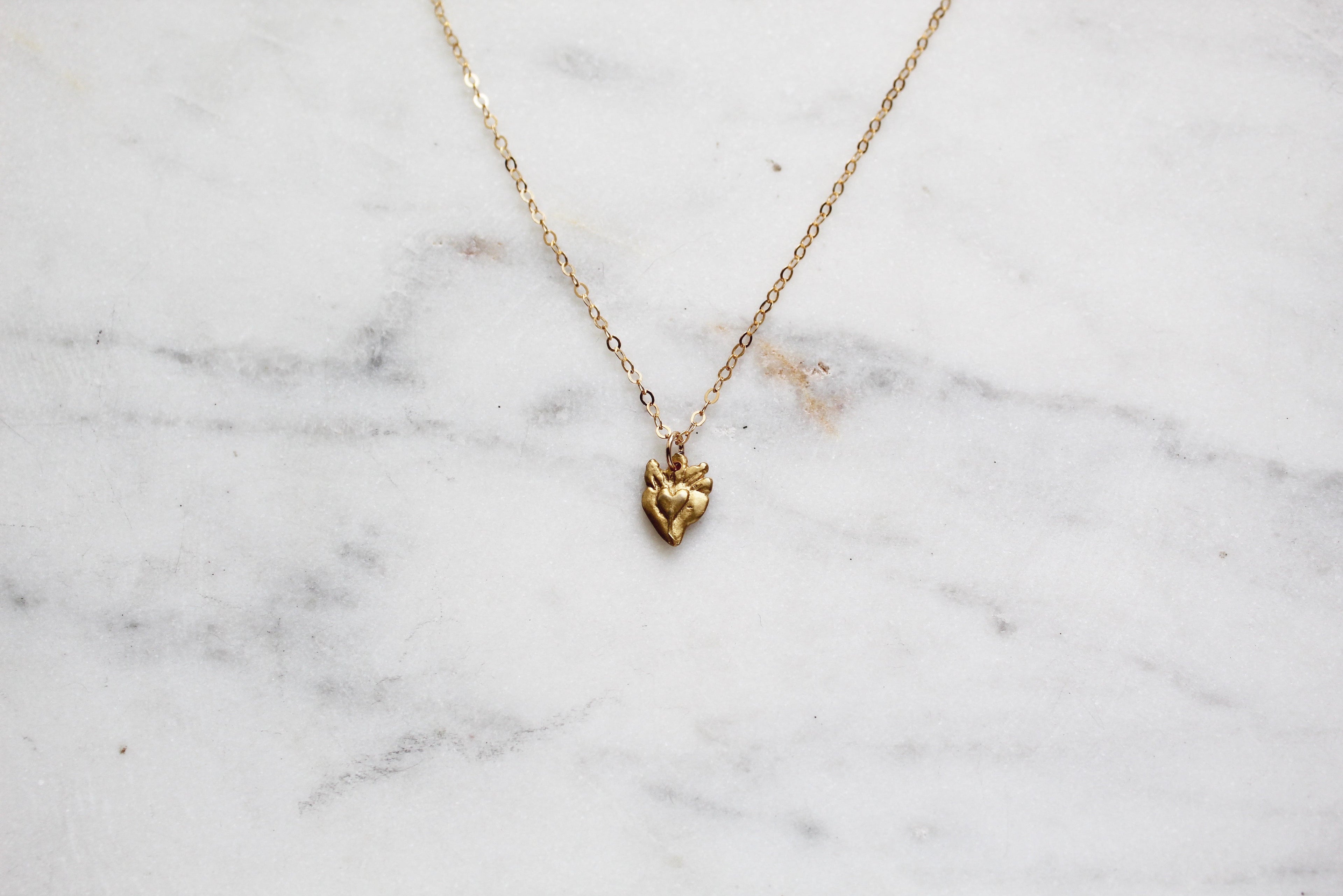 Gold sacred heart pendant necklace on a fine chain
