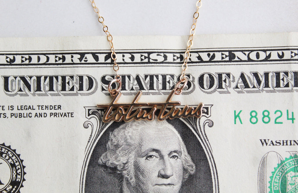 Gold-tone Totus Tuus script pendant on a thin chain necklace