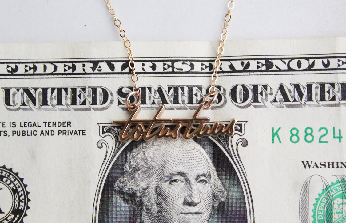 Gold-tone Totus Tuus script pendant on a thin chain necklace