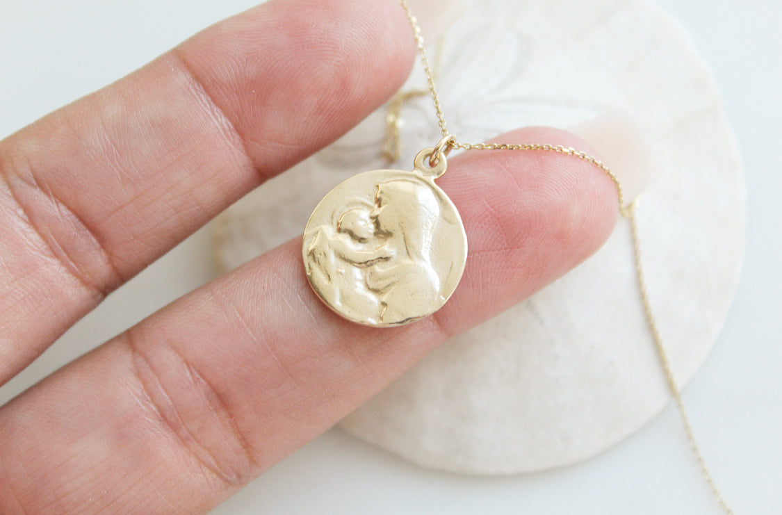 14k gold medallion pendant necklace with Jesus and Mary relief, chain draped