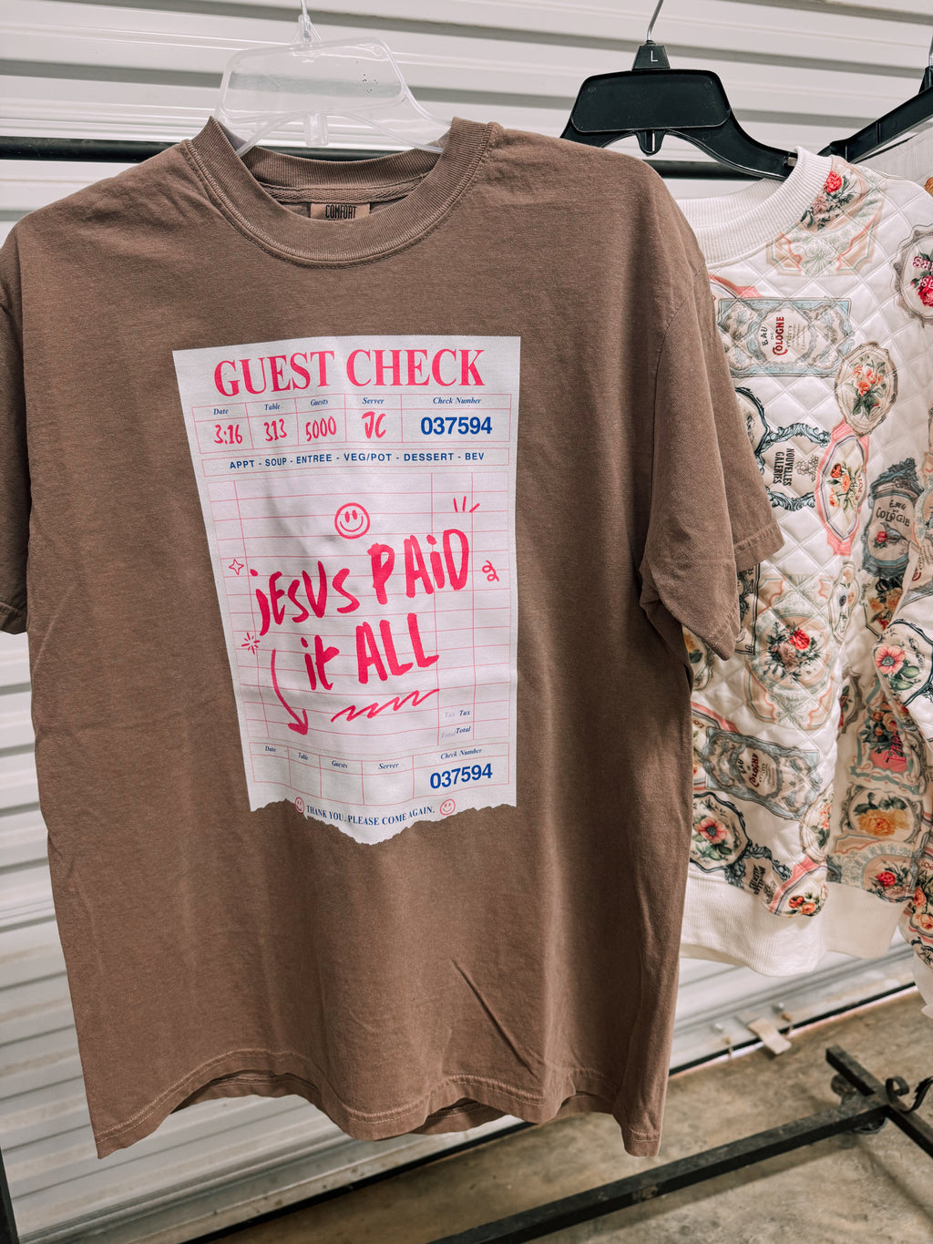 Brown crewneck tee with guest check print and red 'Jesus paid it all' text