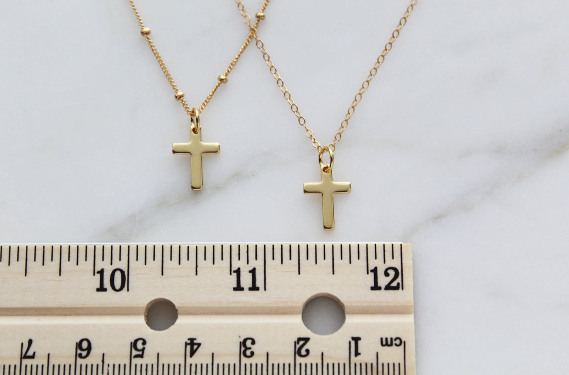 Gold cross pendant necklaces with ruler for size, small cross charms on chains