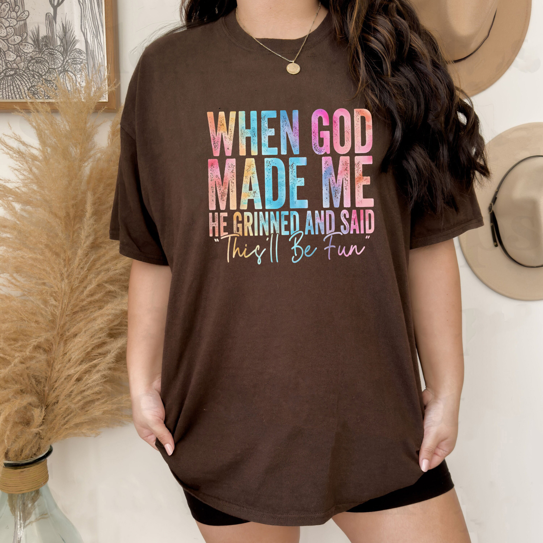 Brown T-shirt with colorful “When God Made Me” graphic text and crew neckline