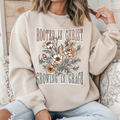 Cream long-sleeve crewneck T-shirt with floral 'Rooted in Christ' front graphic