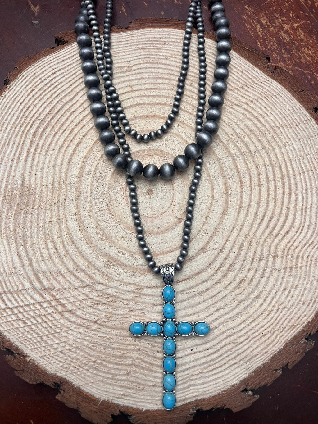 Three-layer cross necklace with dark faux-pearl beads and turquoise cross pendant