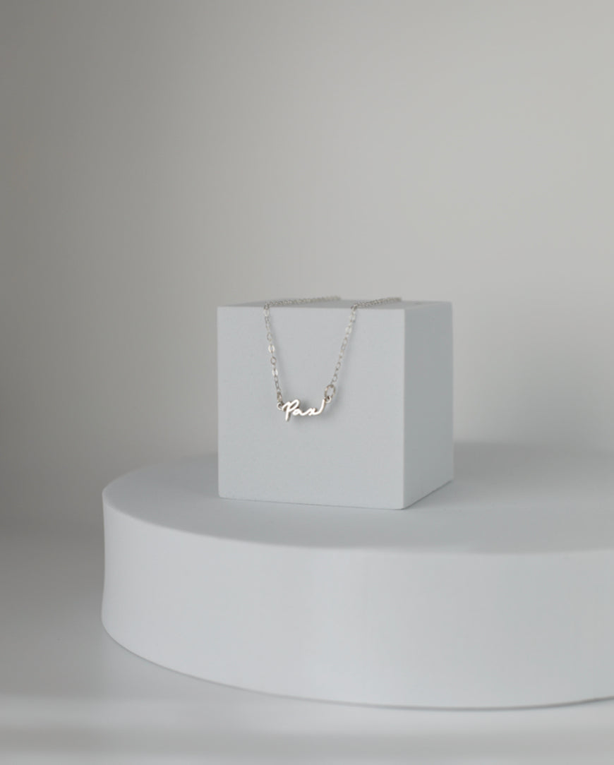 Sterling silver Pax necklace with cursive Pax pendant displayed on a fine chain