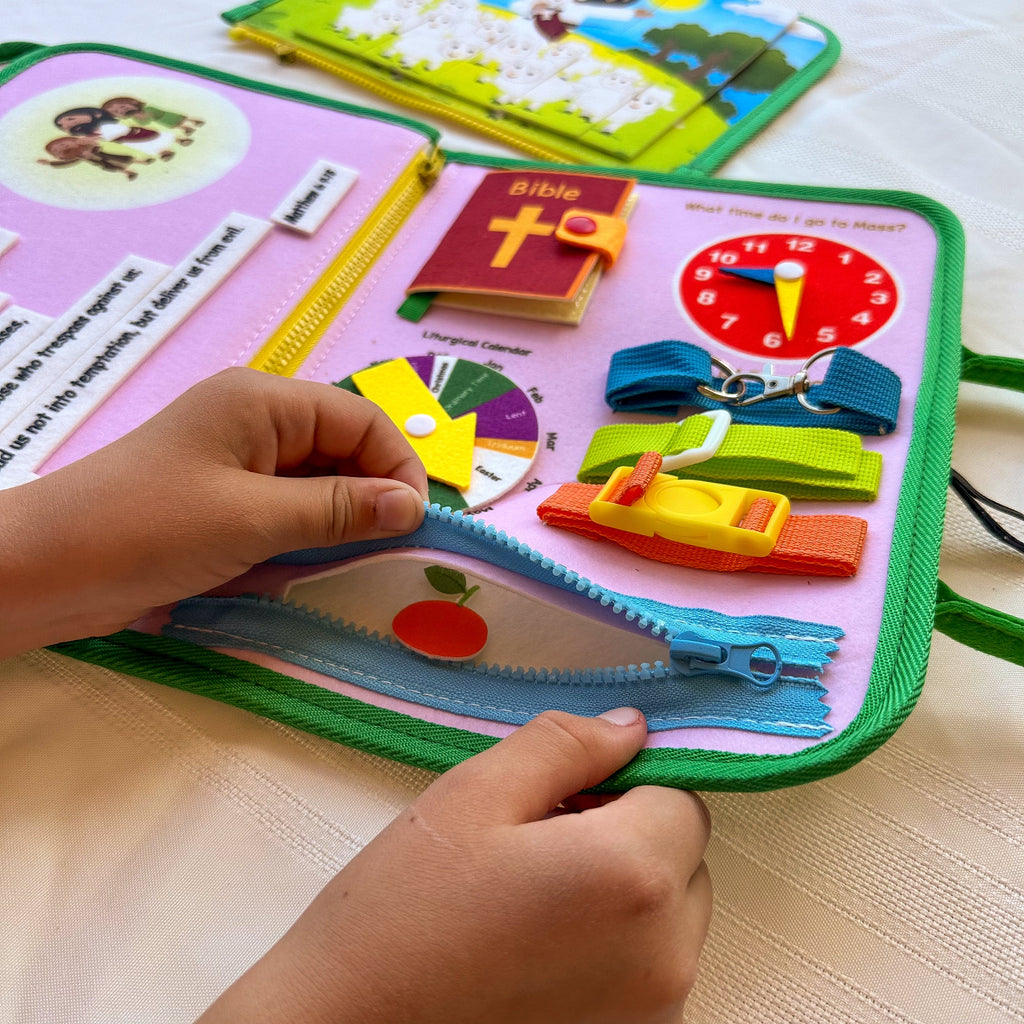 Open felt busy book with colorful Velcro pieces, cross page, and clock