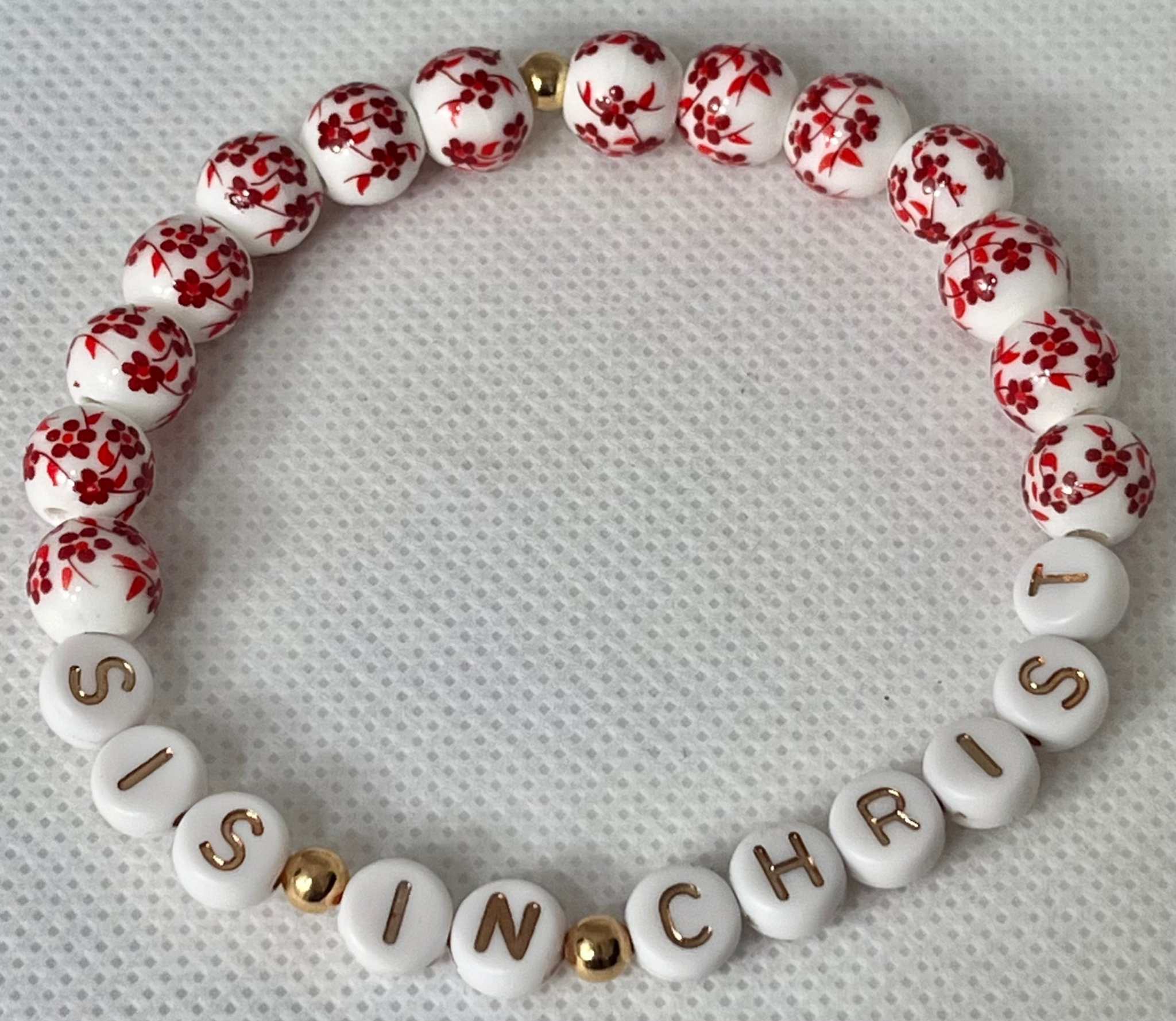 Red and white beaded bracelet with gold spacers and letters spelling IN CHRIST
