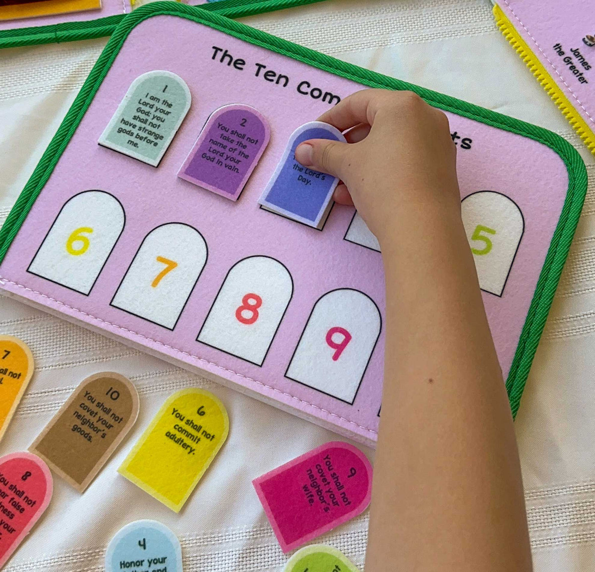 Close-up felt busy book page with numbered doors and small card activities