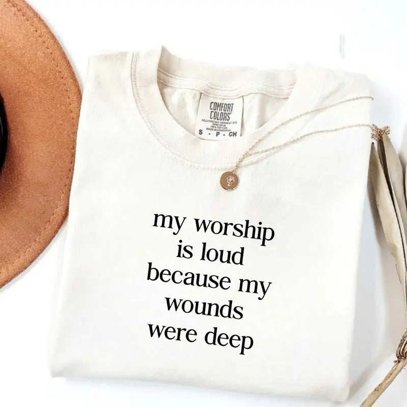 Ivory short-sleeve V-neck T-shirt with light word graphic and gold necklace