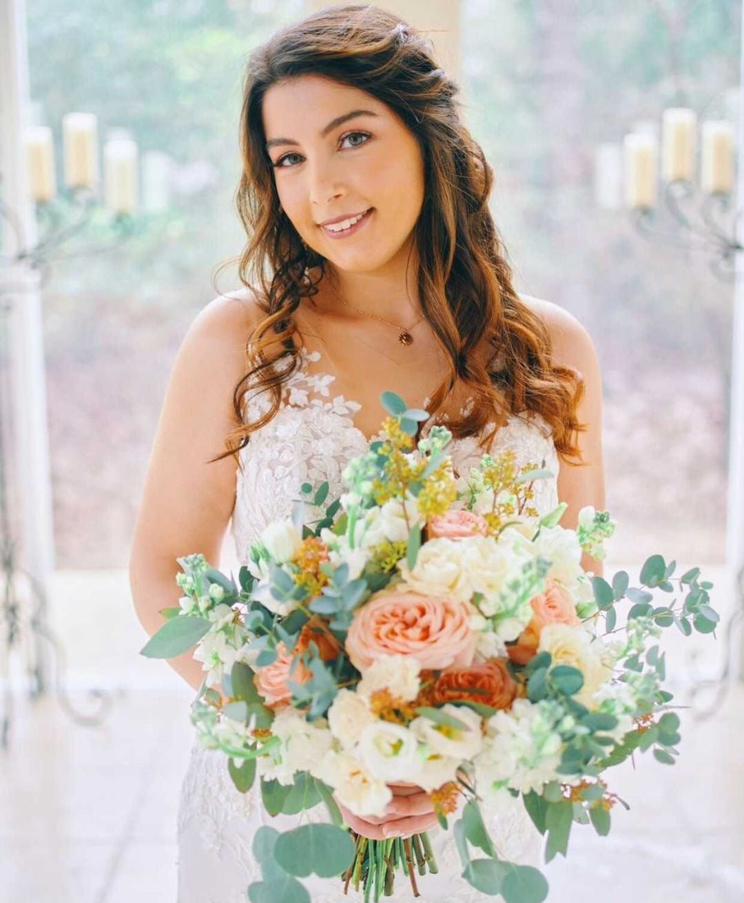Gold-tone scalloped heart charm necklace on a woman holding a flower bouquet