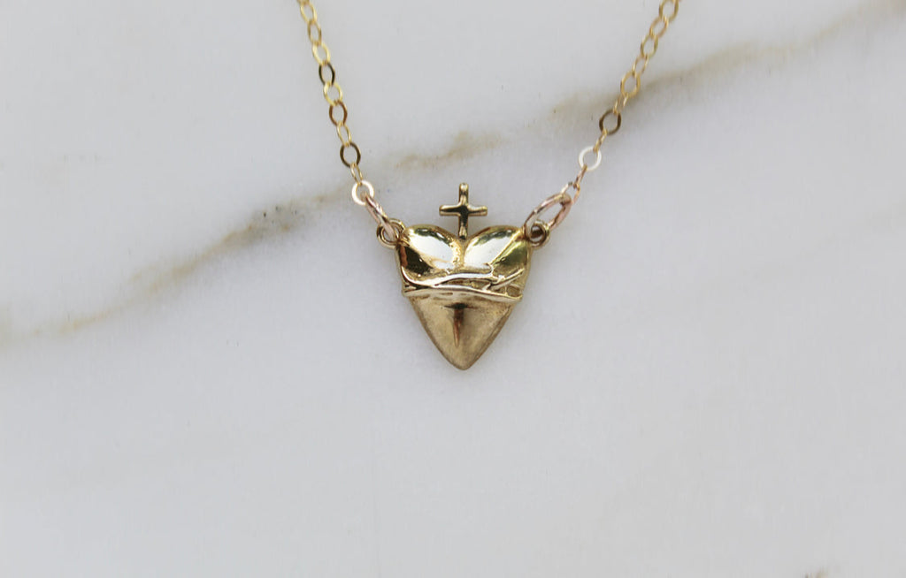 Gold-tone heart pendant necklace with crown and cross centerpiece