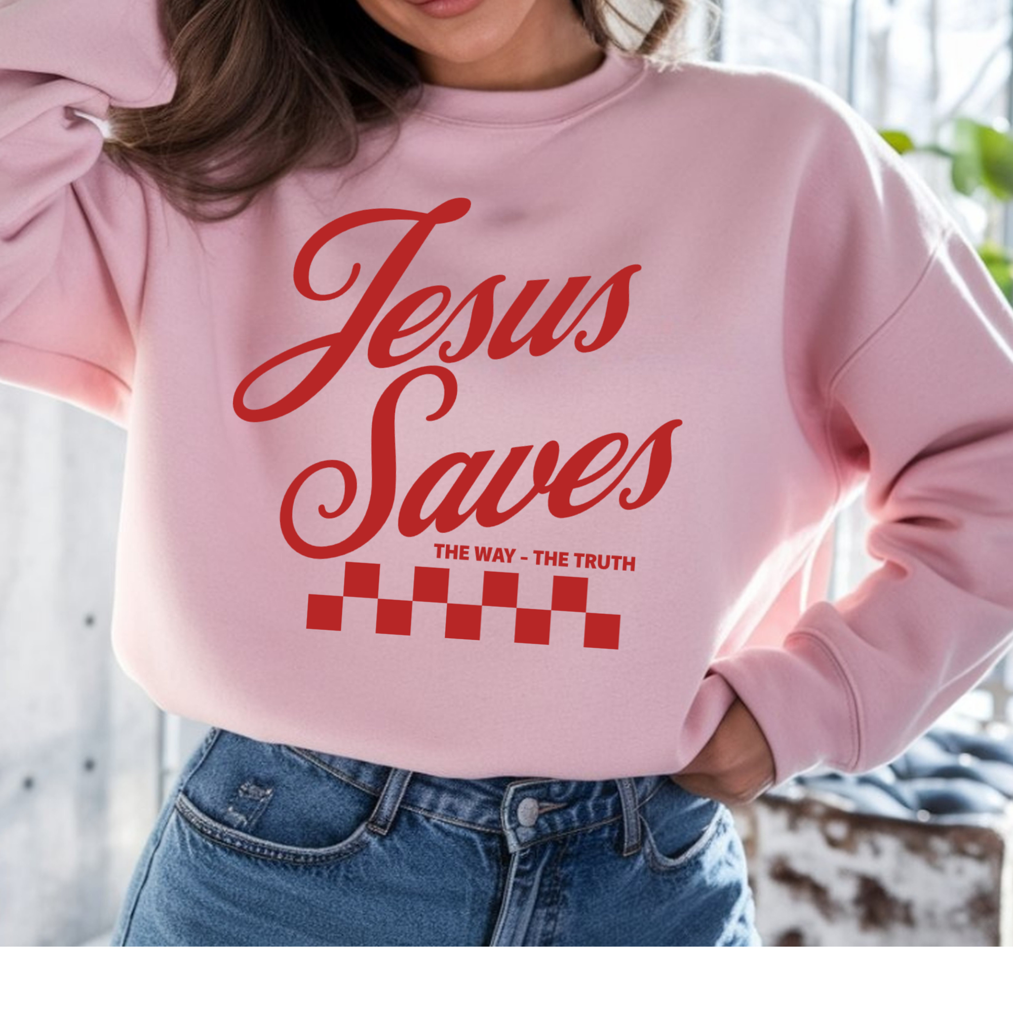Light pink crewneck sweatshirt with red "Jesus Saves" text and checkered graphic