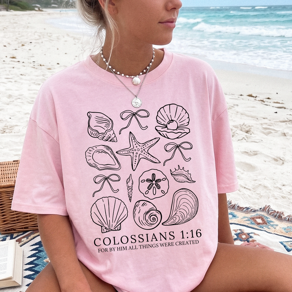 Women's pink Christian graphic T-shirt with seashell artwork and 'Colossians 1:16' text